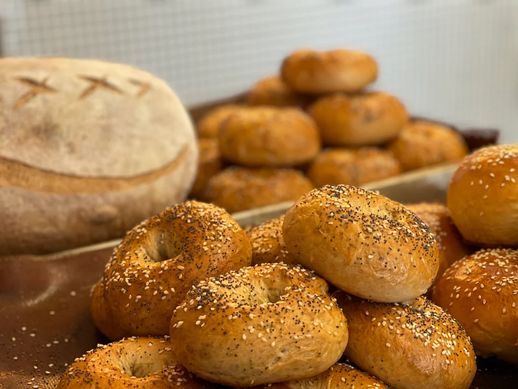 Freshly baked bread at Poached Breakfast Cafe, Chalong, Phuket, Thailand. At the back you have seeded buns and sourdough loaves, in the foreground you have seeded bagels. One of the top cute brunch places in Phuket that serves the best fresh food in Chalong!