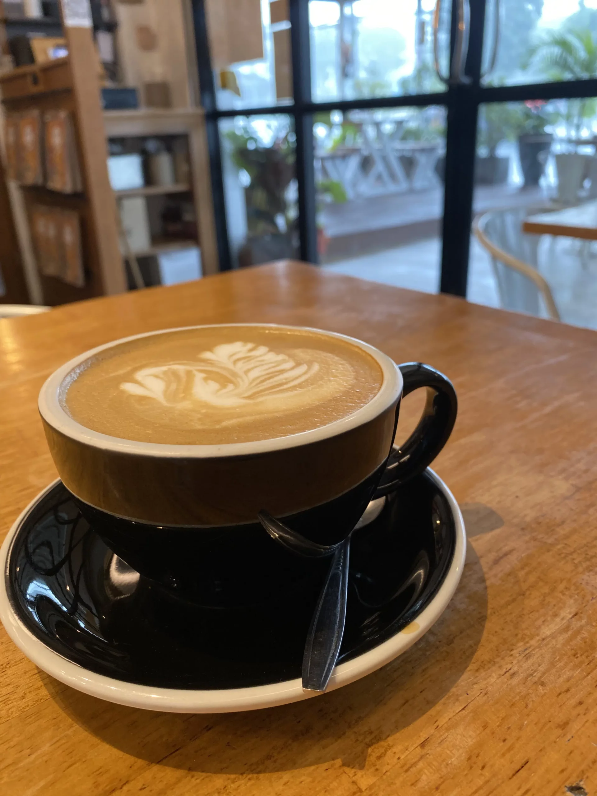 Creamy latte with latte art on a table at Poached Breakfast Cafe, Chalong, Phuket, Thailand. It's the best coffee cafe near me.