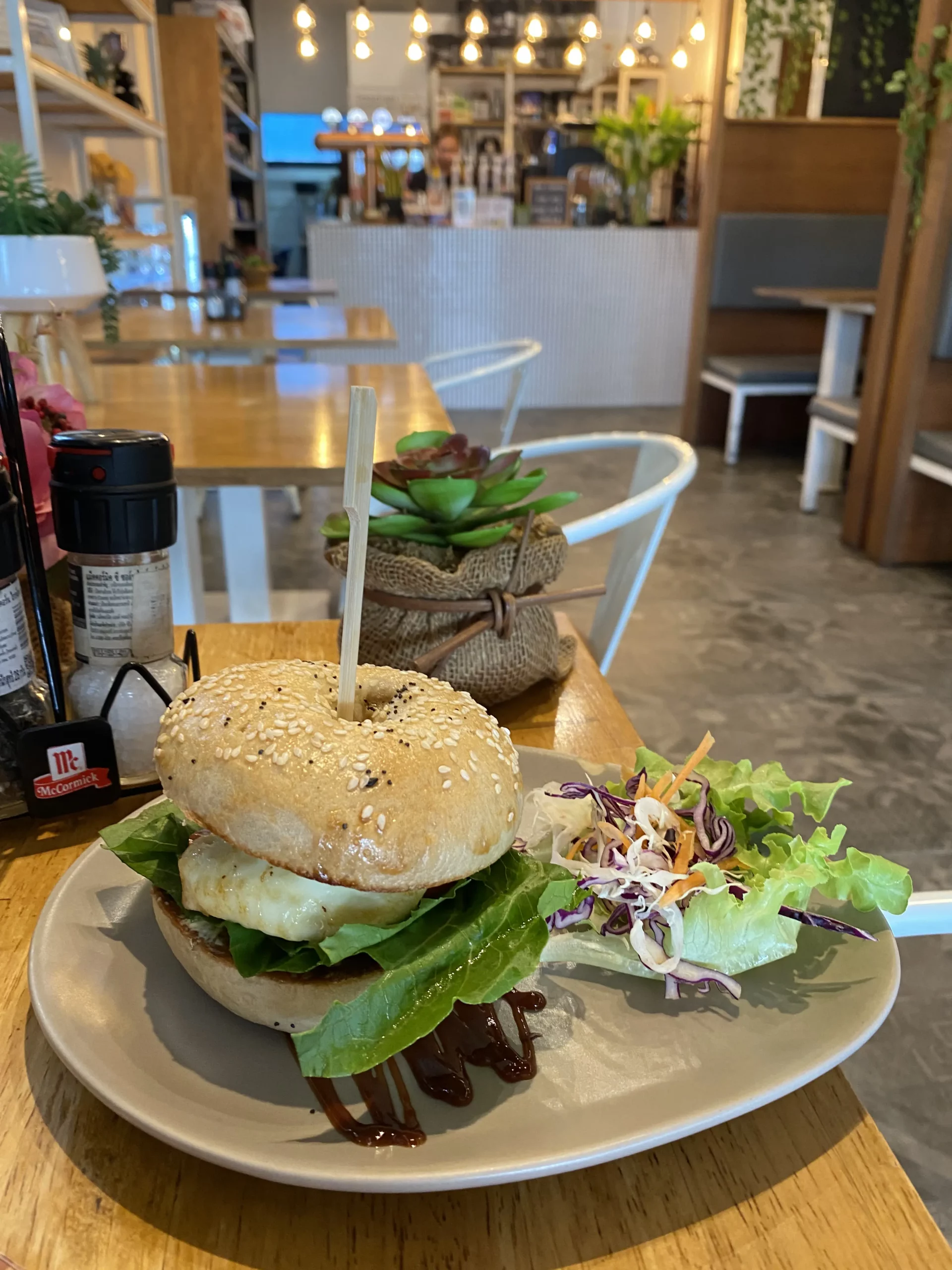 Halloumi bagel with a side salad on a table at at Poached Breakfast Cafe, Chalong, Phuket, Thailand