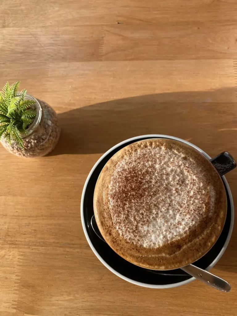 Cappuccino on a table at the best place to start sightseeing in Chalong: Poached Breakfast Cafe, Chalong, Phuket, Thailand