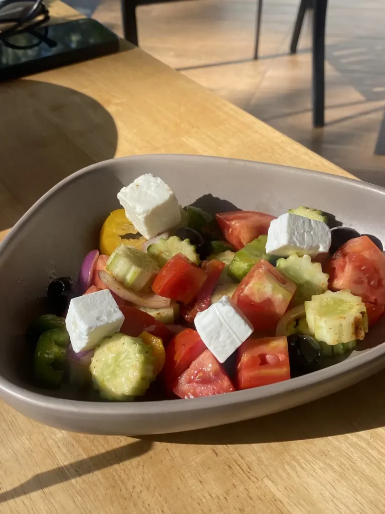 Greek salad with feta, tomatoes, cucumber, onion and olives in the sunshine at Poached Breakfast Cafe: one of the best holiday experiences in Chalong, Phuket, Thailand