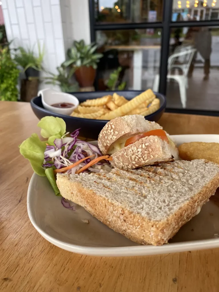 Toasted sandwich on a plate with a side salad and a plate of french fries at the best place for lunch in Chalong - Poached Breakfast Cafe, Chalong, Phuket, Thailand