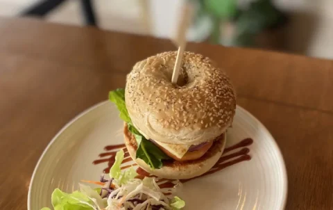 Our holy halloumi bagel on a table by the window. This is the best bagel in Chalong, only found at Poached Breakfast Cafe, Chalong, Phuket, Thailand