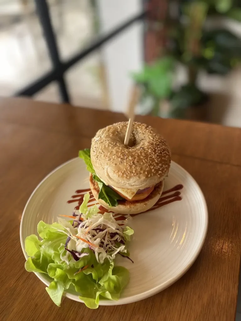 Our holy halloumi bagel on a table by the window. This is the best bagel in Chalong, only found at Poached Breakfast Cafe, Chalong, Phuket, Thailand
