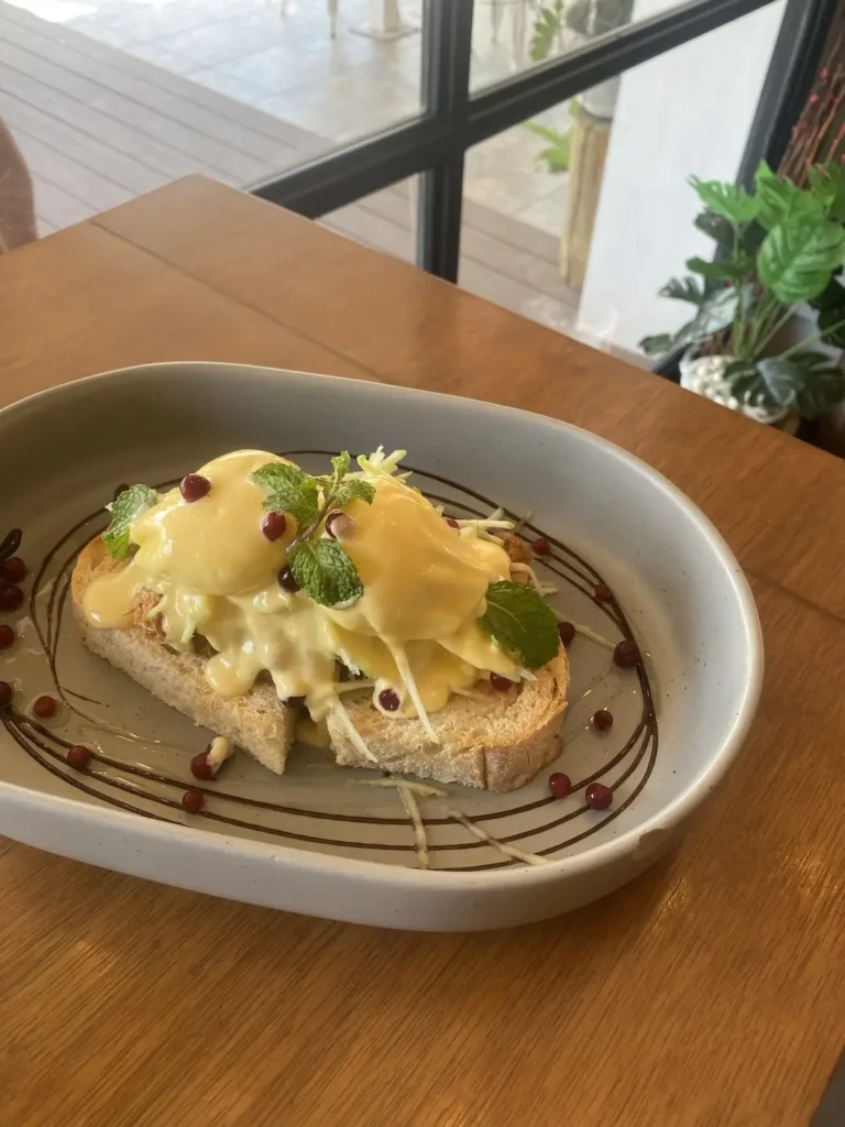 Pulled Pork Eggs Benedict on a table next to a window. A pretty good alternative to avocado toast in Chalong at Poached Breakfast Cafe, Chalong, Phuket, Thailand