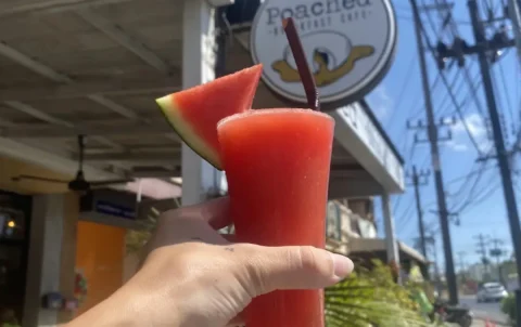 Watermelon smoothie outside with the Poached Cafe sign. A great drink to accompany avocado toast in Chalong at Poached Breakfast Cafe, Chalong, Phuket, Thailand
