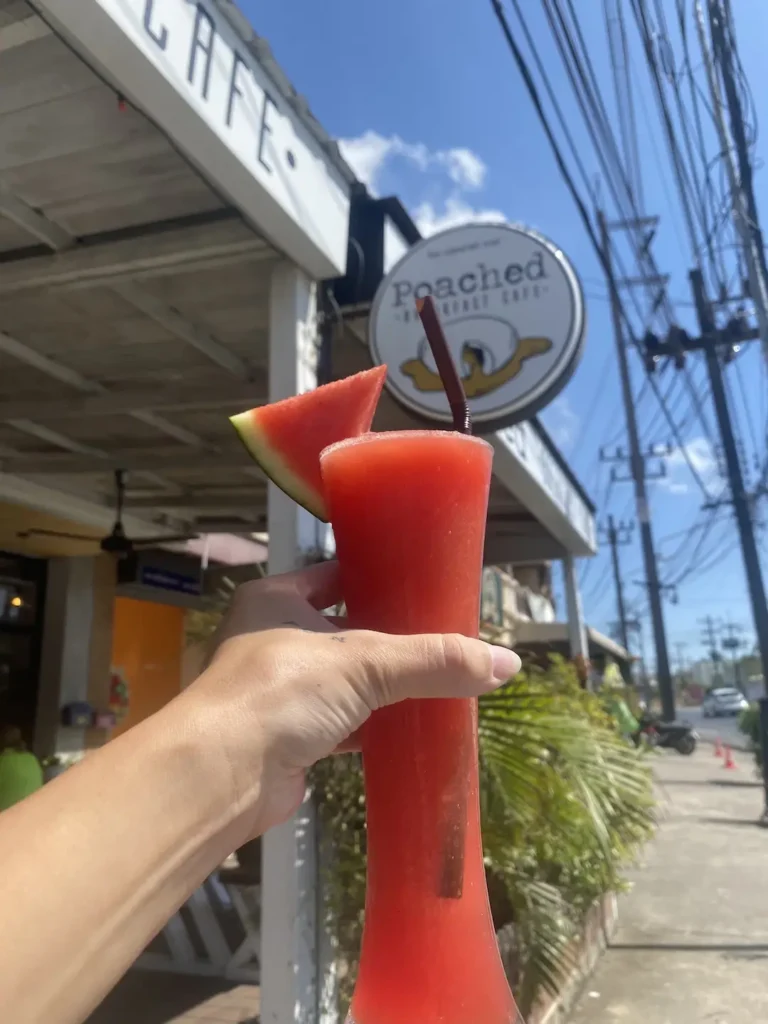Watermelon smoothie outside with the Poached Cafe sign. A great drink to accompany avocado toast in Chalong at Poached Breakfast Cafe, Chalong, Phuket, Thailand