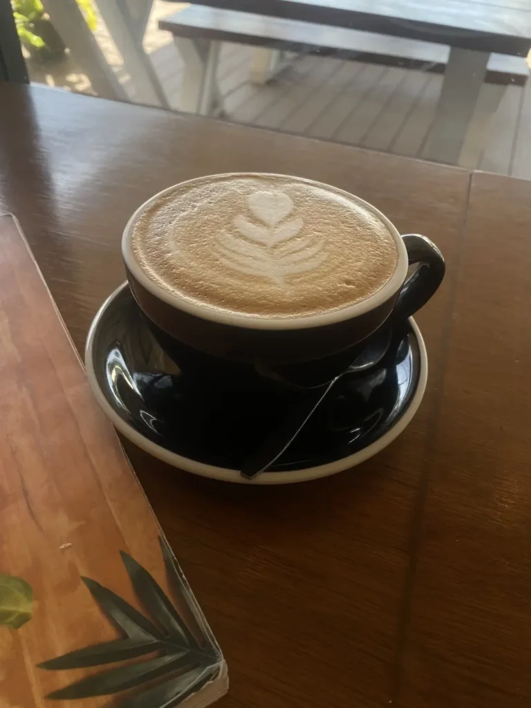 Our smooth, rich latte in a large cup with a leaf design in the foam. Only the best local coffee in Chalong at Poached Breakfast Cafe, Chalong, Phuket, Thailand