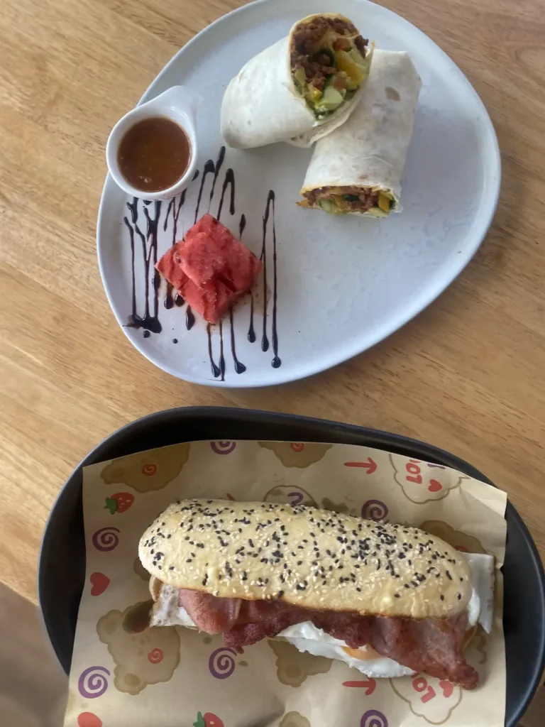 Sausage wrap with dipping sauce and a bacon and egg sandwich at the number one place on the Phuket Travel Guide: Poached Breakfast Cafe, Chalong, Phuket, Thailand