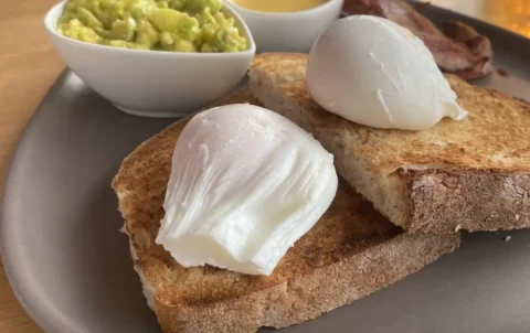 Two perfect poached eggs on sourdough bread with smashed avocado and hollandaise sauce. Only at the best spot to see before you head to one of the amazing islands to visit near Phuket: Poached Breakfast Cafe, Chalong, Phuket, Thailand