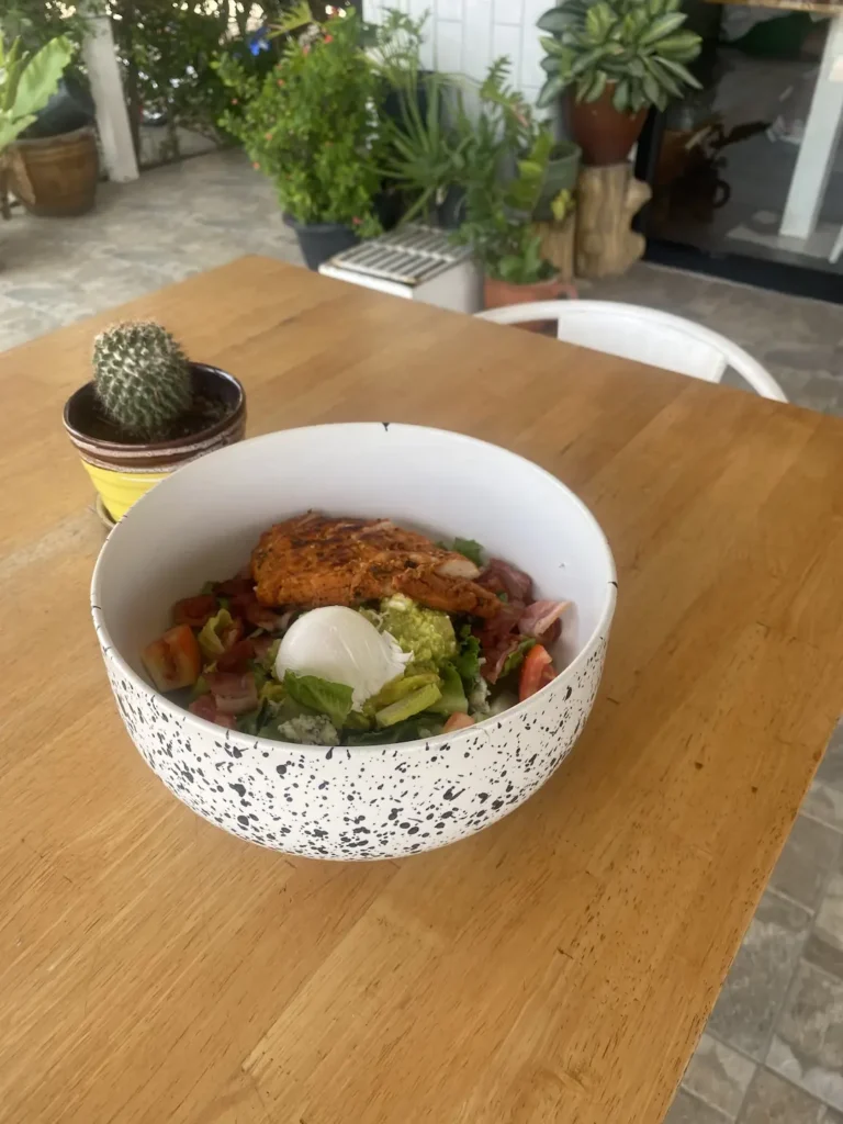 Cobb salad on a table next to a potted cactus at the place to fuel up before taking part in any water activities in Phuket - Poached Breakfast Cafe, Chalong, Phuket, Thailand